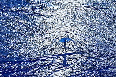 Groundsmen cover the pitch due to rains